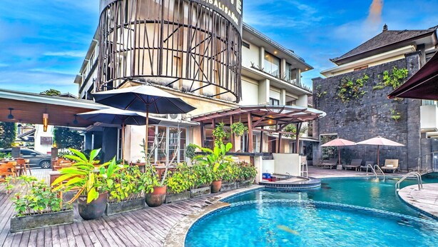 A hotel with a pool, outdoor seating, and potted plants. - Luxury Two Bedroom Villa with Pool and WiFi Access (Bali)
