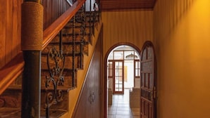 Un escalier en bois, doté d’une rampe, mène à une porte dont le panneau est en verre.