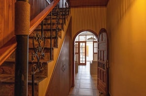 A wooden staircase with a handrail, leading to a doorway with a glass panel. - Casa Mari. (Agaete)