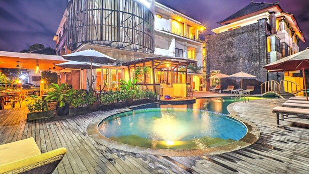 Un hôtel doté d’une piscine, d’un espace extérieur aménagé et d’un bâtiment moderne à l’architecture cylindrique originale.