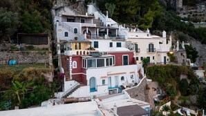 Un edificio a terrazze su una collina, con diversi livelli, balconi e un mix di stili architettonici.