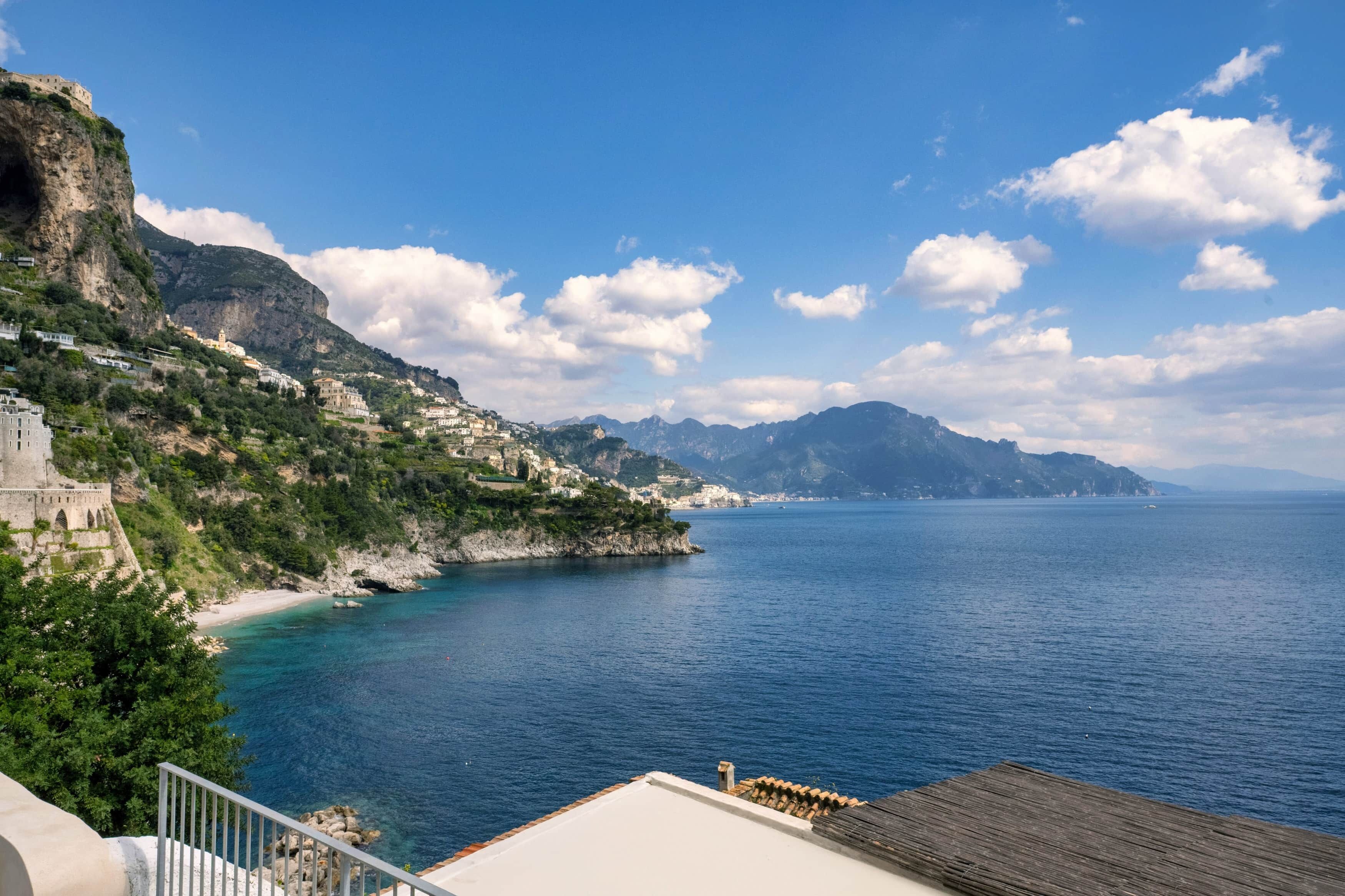 A coastal view with buildings, a beach, and a clear sky.