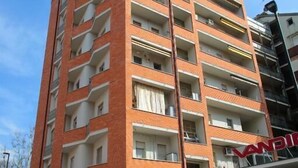 A multi-story building with a brick facade, balconies, and a sign that reads 'VANESSA.' - Federica Flat - Metro Monte Grappa (Turin)