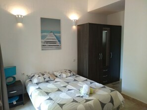 Ein Schlafzimmer mit Bett, Kleiderschrank, Gemälde und Nachttisch.