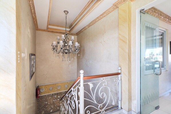 Una escalera con barandilla blanca y un candelabro.