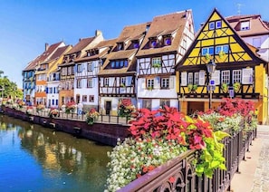 A row of colorful half-timbered houses along a canal. - LOFT APARTMENT PETITE VENISE RIVER VIEW WITH PRIVATE PARKING (Colmar)