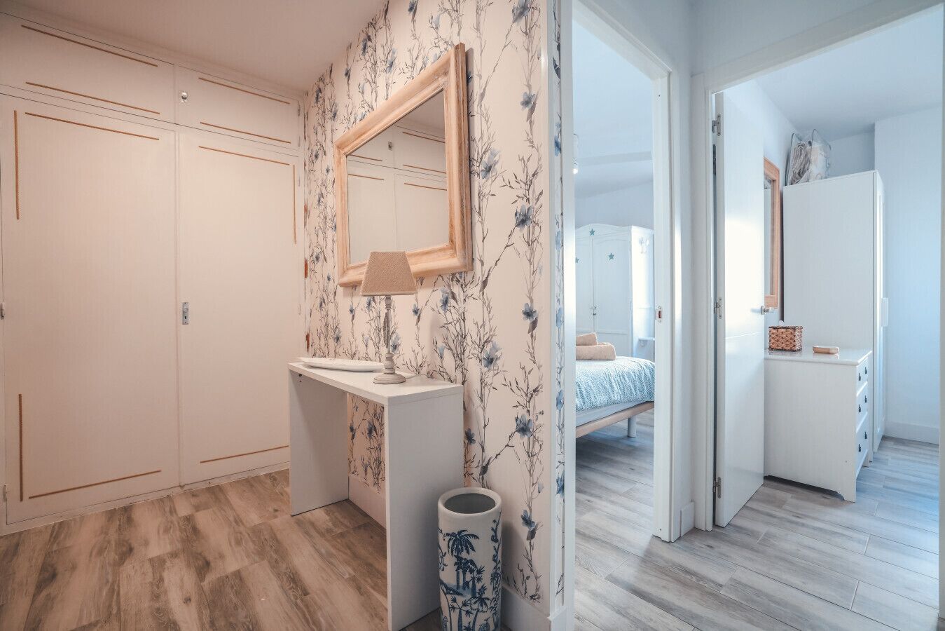 Une chambre à coucher avec un lit, une table de chevet, un miroir et une armoire.