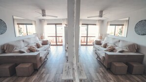 A symmetrical living room with two sofas, a coffee table, and a central column. - Baylight Retreat Apartment (El Puerto de Santa María)