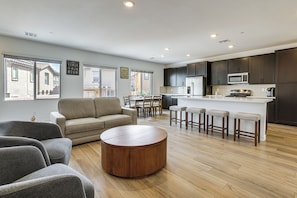 A modern kitchen with dark cabinets, a central island, and bar stools.