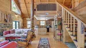 A wooden cabin interior with a living area, kitchen, and staircase. - Fish & Float at Natural Springs! Log Cabin in Bell (Bell)