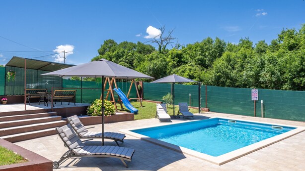 A backyard with a swimming pool, lounge chairs, a slide, and a covered seating area. - Villa Danijela by Villas Guide (Barban)