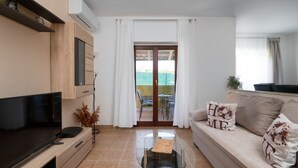 A living room with a TV, sofa, and a glass coffee table. - Villa Danijela by Villas Guide (Barban)