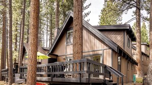 Eine Holzhütte mit Terrasse und einer Treppe, die zum Eingang führt.