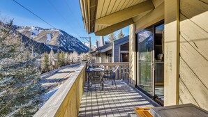 A wooden balcony with a view of snow-covered trees and mountains. - Walk to Town & Slopes, Views, SPA & Sauna Access (Ketchum)
