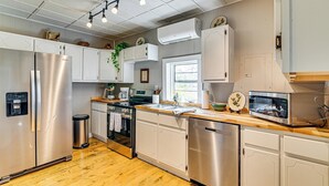 A modern kitchen with stainless steel appliances, white cabinetry, and a wooden countertop. - Surrounding Pasture Views! Peaceful Escape in Iuka (Iuka)