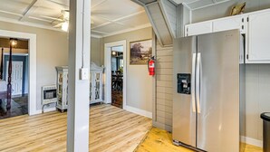 A kitchen with a stainless steel refrigerator, wooden flooring, and a white cabinet. - Surrounding Pasture Views! Peaceful Escape in Iuka (Iuka)