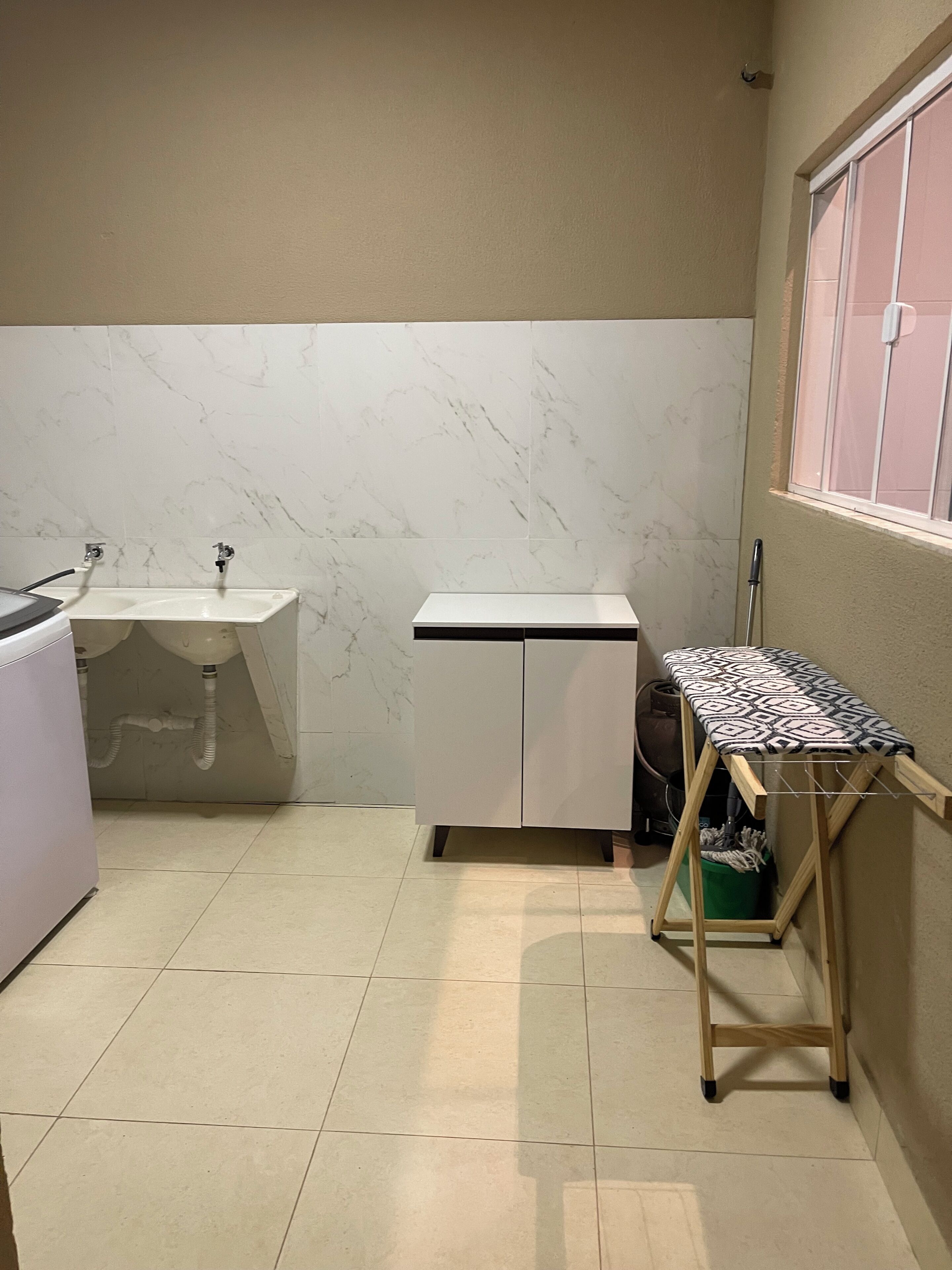 A small kitchen with a sink, a countertop, and a window.