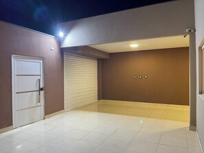 A clean, modern hallway with a closed door, a sliding door, and a wall-mounted light fixture.