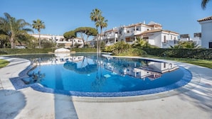 A swimming pool with a clear blue water, surrounded by a tiled deck. - Barrosa Beach Apartment -Chiclana de la Frontera (Chiclana de la Frontera)