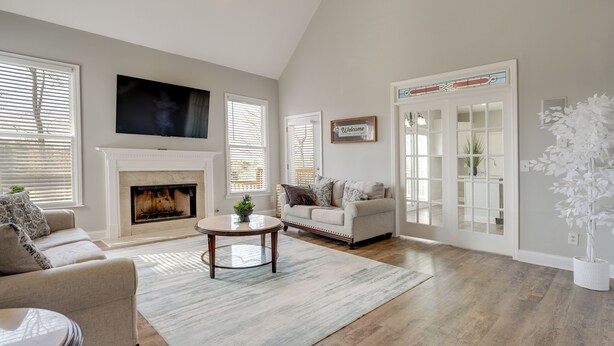 A living room with a fireplace, a sofa, a coffee table, and a television. - Private Yard & Pool Access! Family Home in Acworth (Acworth)