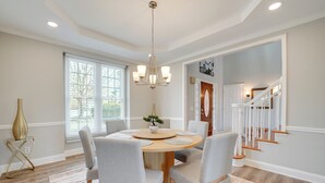 A dining area with a round table, chairs, a chandelier, and a staircase. - Private Yard & Pool Access! Family Home in Acworth (Acworth)