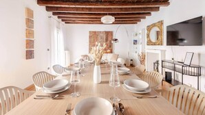 Comedor con techo de madera, televisor y chimenea.