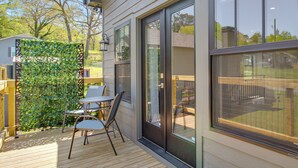 A deck with outdoor seating, a glass door, and a view of the backyard. - Walkable North Georgia Hideaway! Modern Suite (Ball Ground)