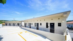 Un bâtiment comprenant plusieurs pièces, un espace de stationnement et un ciel dégagé.