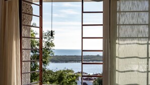 A window with a view of a body of water and greenery. - Atlantic View Apartment - El Rompido (El Rompido)