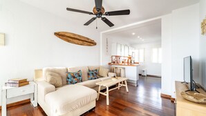 A modern living room with a sofa, a wooden coffee table, and a ceiling fan. - Atlantic View Apartment - El Rompido (El Rompido)