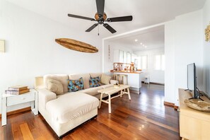A modern living room with a sofa, a wooden coffee table, and a ceiling fan. - Atlantic View Apartment - El Rompido (El Rompido)