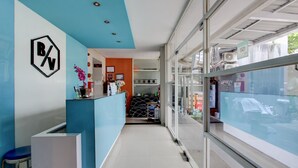 A reception area with a blue and white color scheme, a logo on the wall, and a view of the street through large windows.
