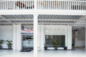 A hotel entrance with a sign for 'ZaaRa Guest House Syariah' and a discount sign for 'Pesan Kamma Offline.'