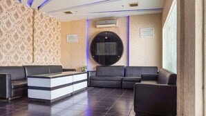 Un espace d’accueil comprenant un canapé, un comptoir de réception et un téléviseur fixé au mur.