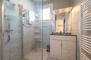 A bathroom with a glass shower door, a white vanity with a mirror, and a towel rack. - Holiday Home 'La Maison Et L'étang De Pêche' with Mountain View, Private Terrace and Wi-Fi (Vagney)