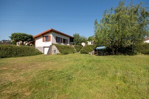 Een woonwijk met een huis, een boom en een bord.