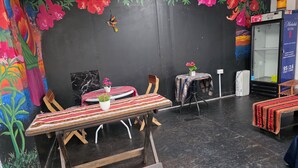 Een eethoek met een tafel, stoelen en een bijzettafeltje met een potplant.
