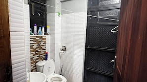 Un baño con inodoro, lavamanos y armario.
