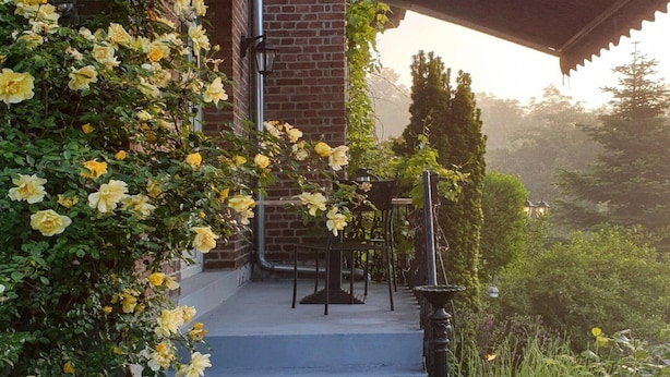 A staircase leading to a covered porch with a brick wall, a table, and chairs. - Villa with swimming pool near Durbuy (Barvaux)