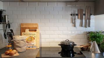 Een koffiezetapparaat/waterkoker, een koelkast, een oven, een kookplaat