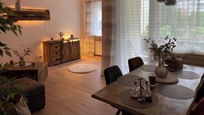 Ein Essbereich mit einem Holztisch, Stühlen und einer Blumenvase.
