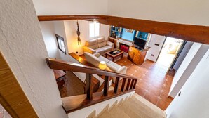 En trappa som leder upp till ett vardagsrum med en soffa, ett soffbord och en tv.