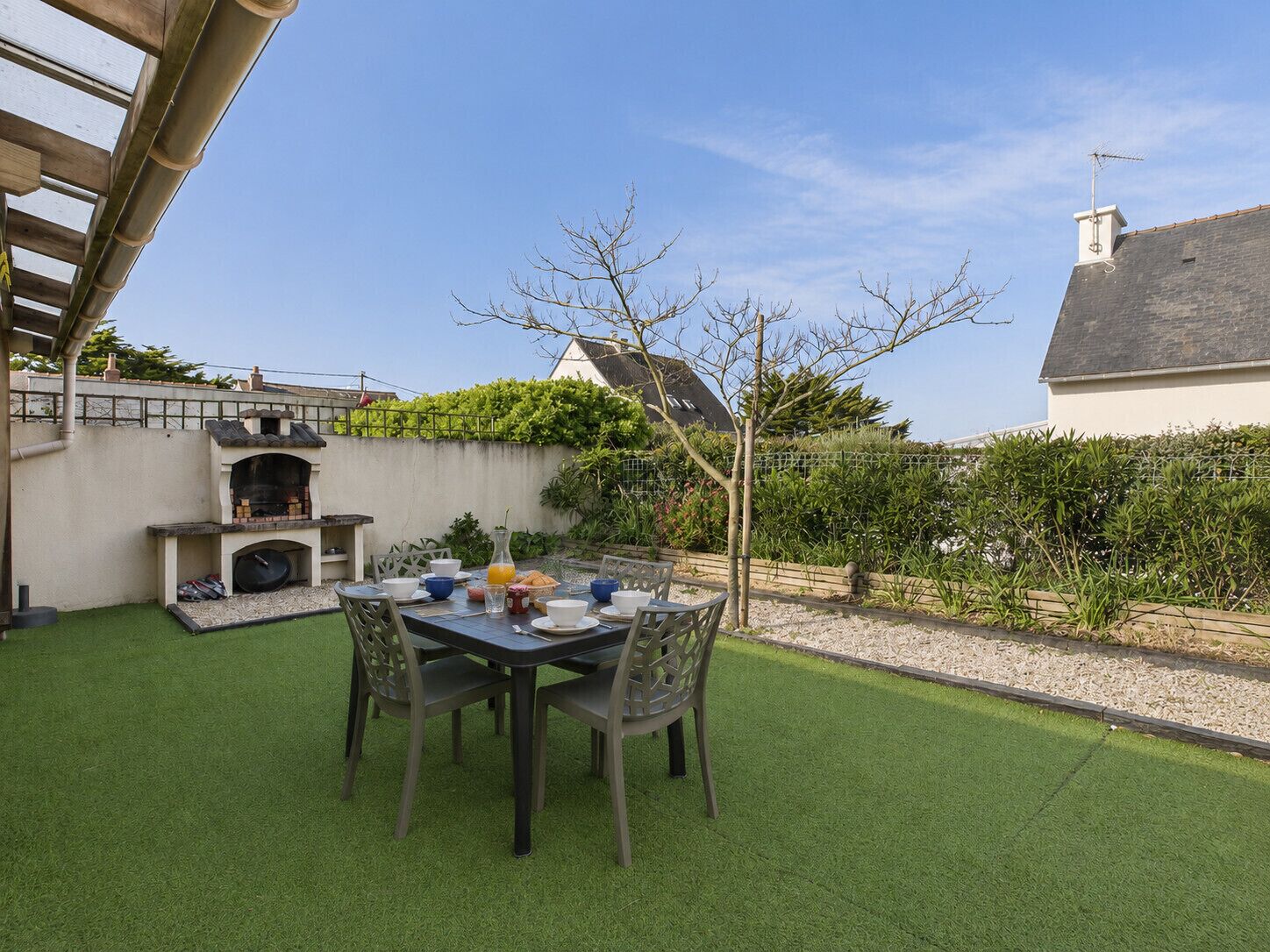 Eine Terrasse im Freien mit Esstisch und Stühlen.