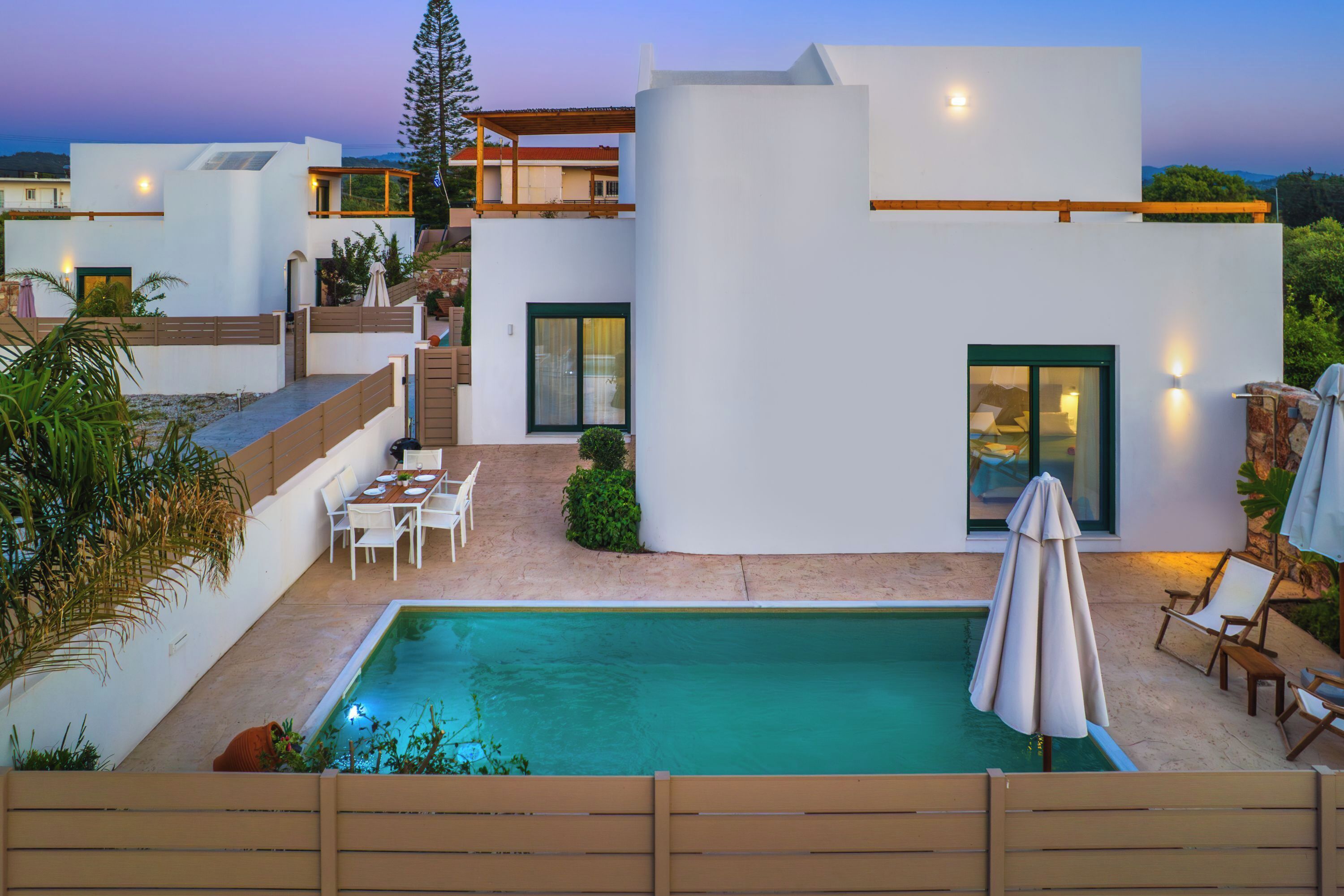 A modern house with a swimming pool, outdoor seating, and a staircase.