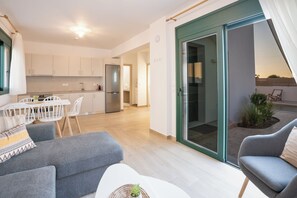 A modern apartment with a kitchen, dining area, and a balcony with plants. - Gemini Villas - Horizon (Rhodes)