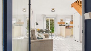 A modern interior with a sofa, dining table, and kitchen area.