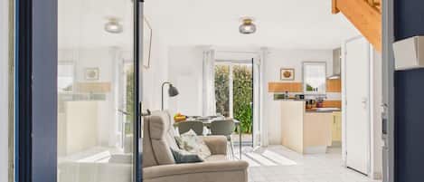 Ein modernes Interieur mit einer Couch, einem Esstisch und einer Küchenzeile.