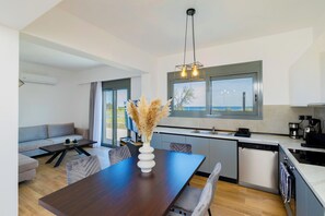 Une cuisine moderne avec un coin repas, un canapé et une vue sur l’extérieur.