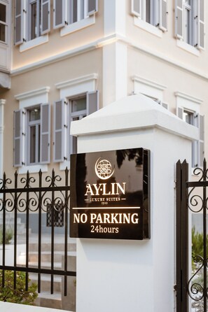 Ein Schild für die Aylin Luxury Suites mit der Aufschrift 'KEIN PARKPLATZ, 24 Stunden'.