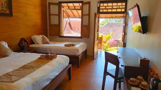 A hotel room with two beds, a desk, a chair, and a TV. - Bawangan Bromo  (Ngadisari)